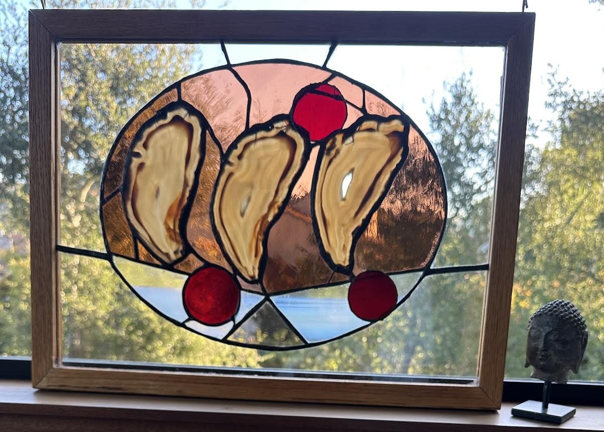 Dancing Pork Chops, a whimsical round stained glass panel with oyster shapes