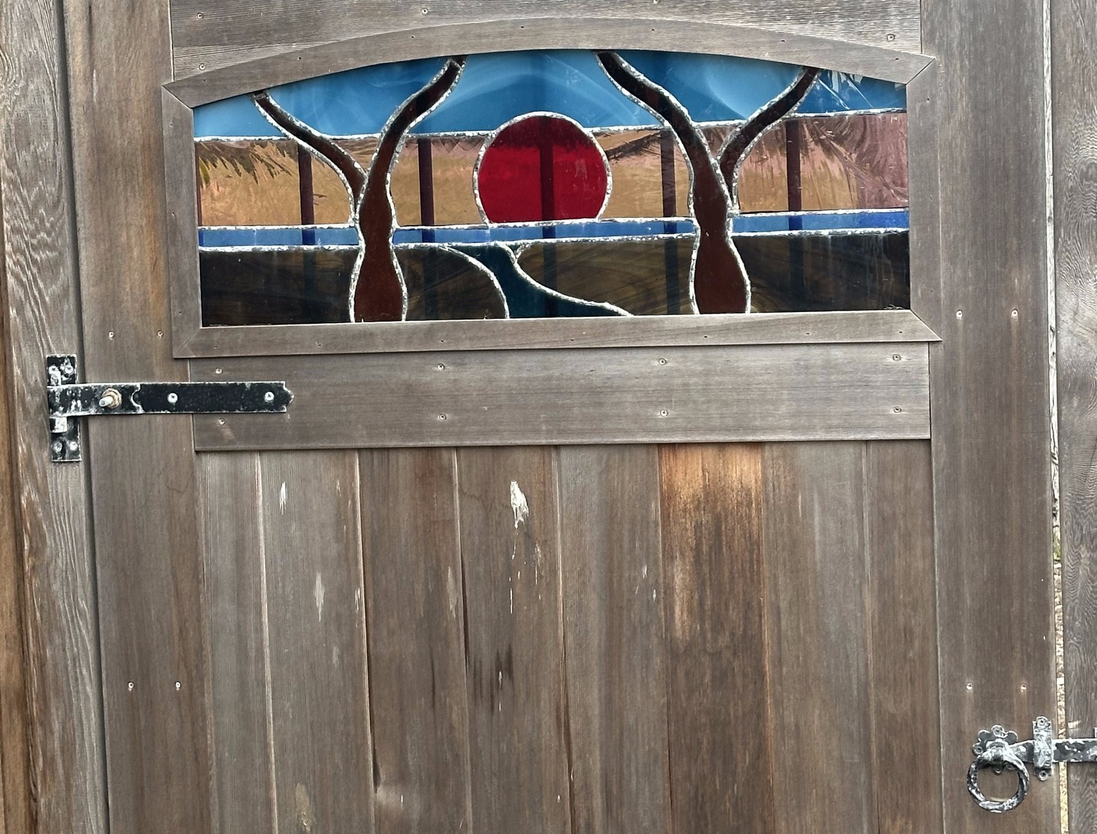 Garden gate with stained glass sun and tree design