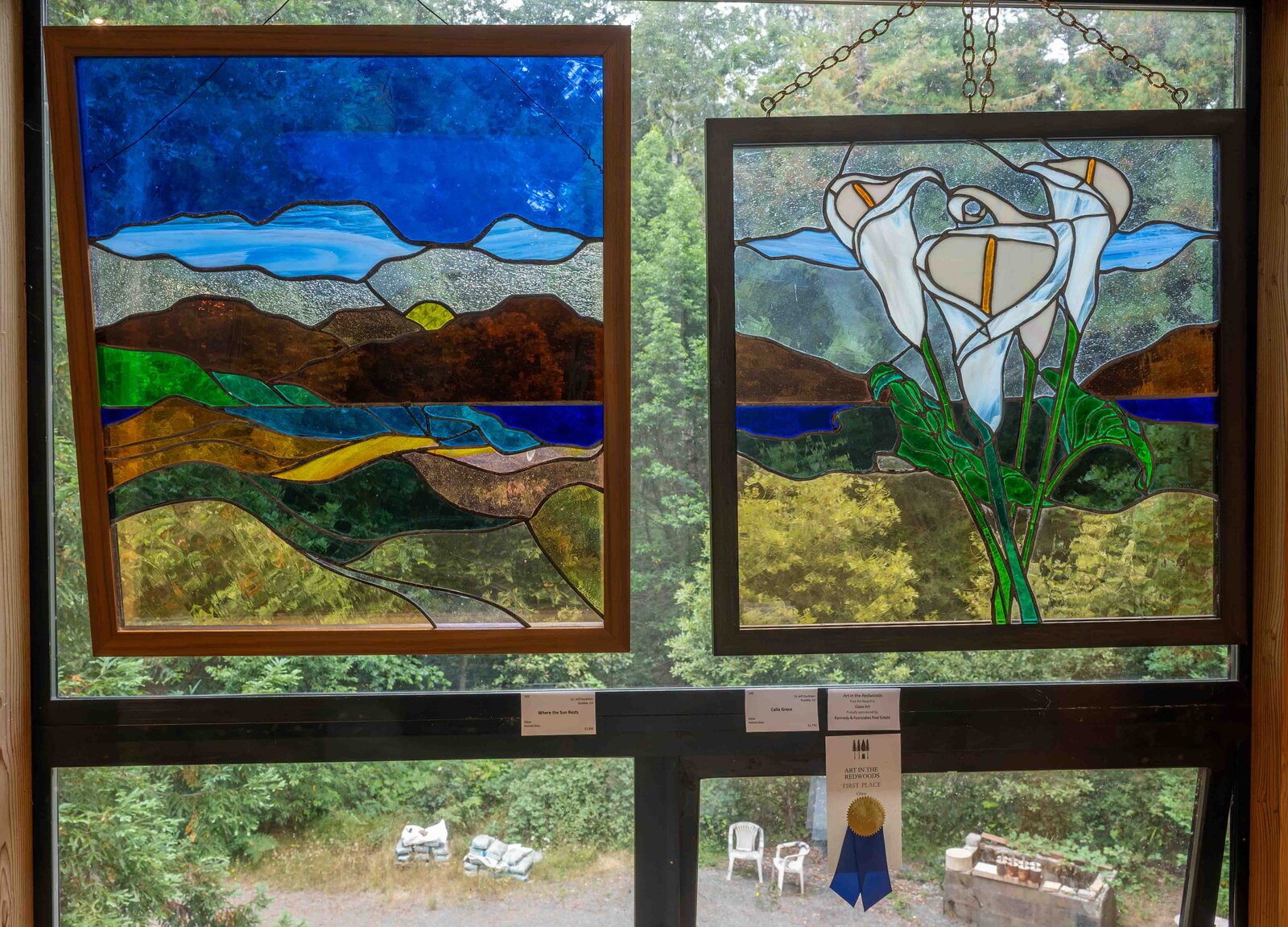 Where the Sun Rests and Calla Grace on display at Art in the Redwoods, with the First Place Glass Art ribbon
